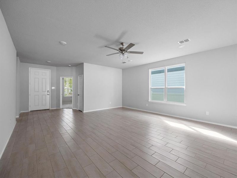 Unfurnished living room featuring light wood-type flooring, plenty of natural light, and a ceiling fan Unfurnished living room featuring light wood-type flooring, plenty of natural light, and a ceiling fan