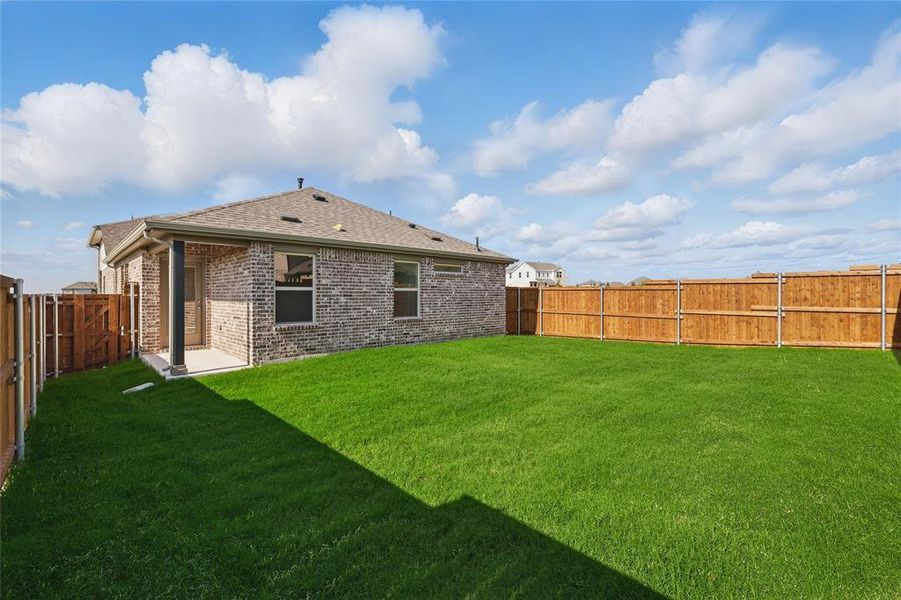 Rear view of property featuring a fenced backyard, brick siding, and a shingled roof Rear view of property featuring a fenced backyard, brick siding, and a shingled roof