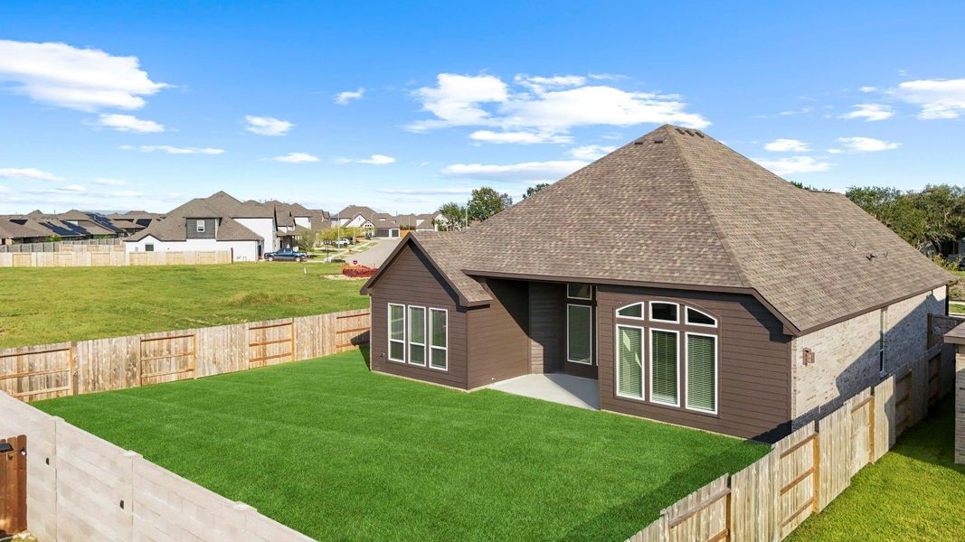 Backyard perspective highlighting the extended lawn and privacy fencing, ideal for play, pets, or gardening.