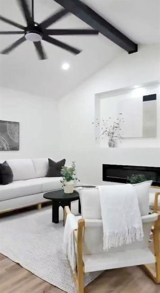 Vaulted ceiling with exposed black beam and ceiling fan