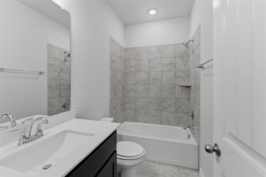 Bathroom featuring a single vanity with dark cabinetry and a white countertop, an undermount sink, and chrome fixtures Bathroom featuring a single vanity with dark cabinetry and a white countertop, an undermount sink, and chrome fixtures
