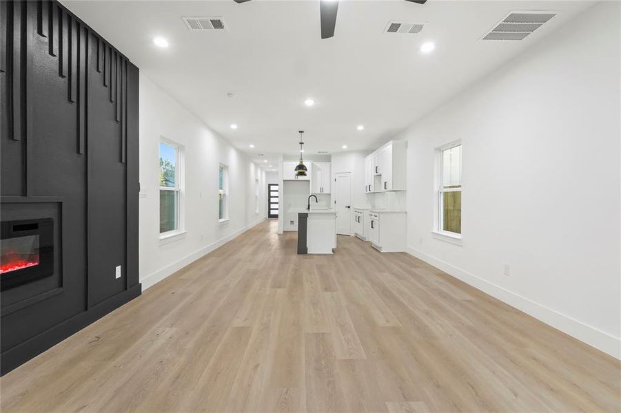 Unfurnished living room featuring recessed lighting, light wood-type flooring, a fireplace, and ceiling fan Unfurnished living room featuring recessed lighting, light wood-type flooring, a fireplace, and ceiling fan