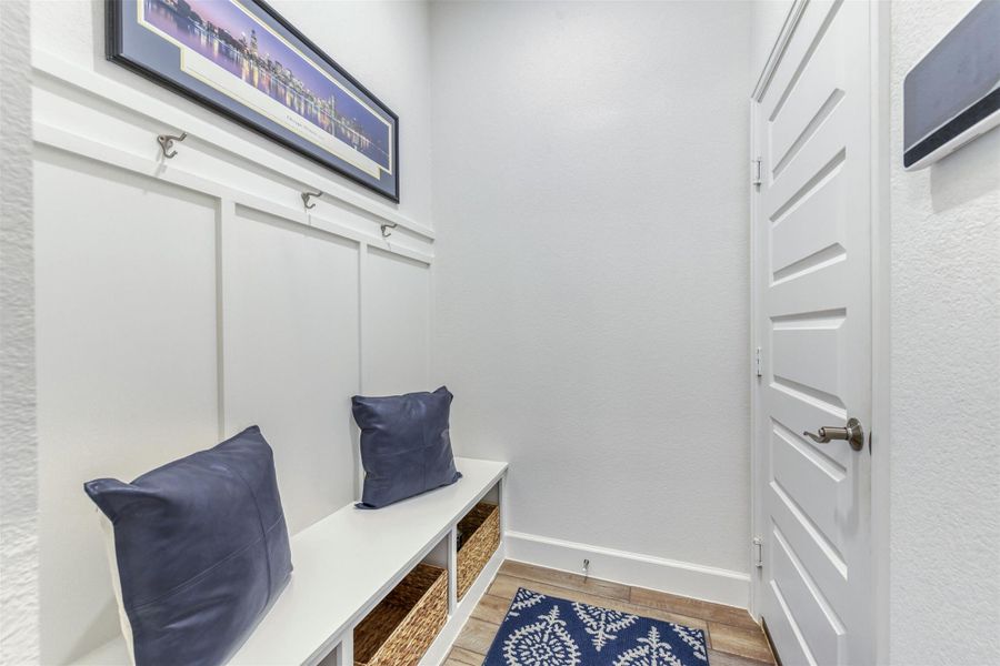Mudroom featuring wood finished floors and a textured wall