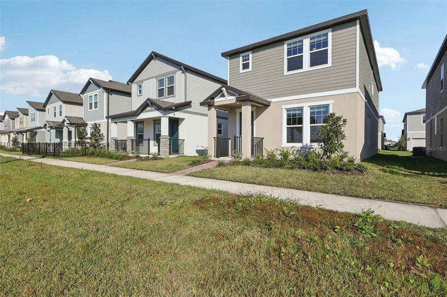 Front exterior of a new home in The Meadow at Crossprairie Bungalows, St. Cloud, FL, highlighting curb appeal (Image 2).