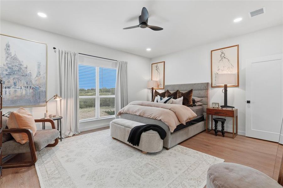 Spacious bedroom featuring wood-finish flooring, a large window with blinds, recessed lighting, and a contemporary ceiling fan