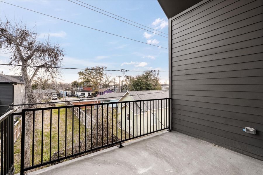 A private balcony extends the primary suite outdoors, offering elevated neighborhood views and a quiet place to start or end the day.