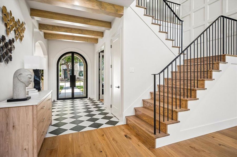 Entry, checkered marble tile floor, exposed wood beams, iron stair railing, wood treads Entry, checkered marble tile floor, exposed wood beams, iron stair railing, wood treads