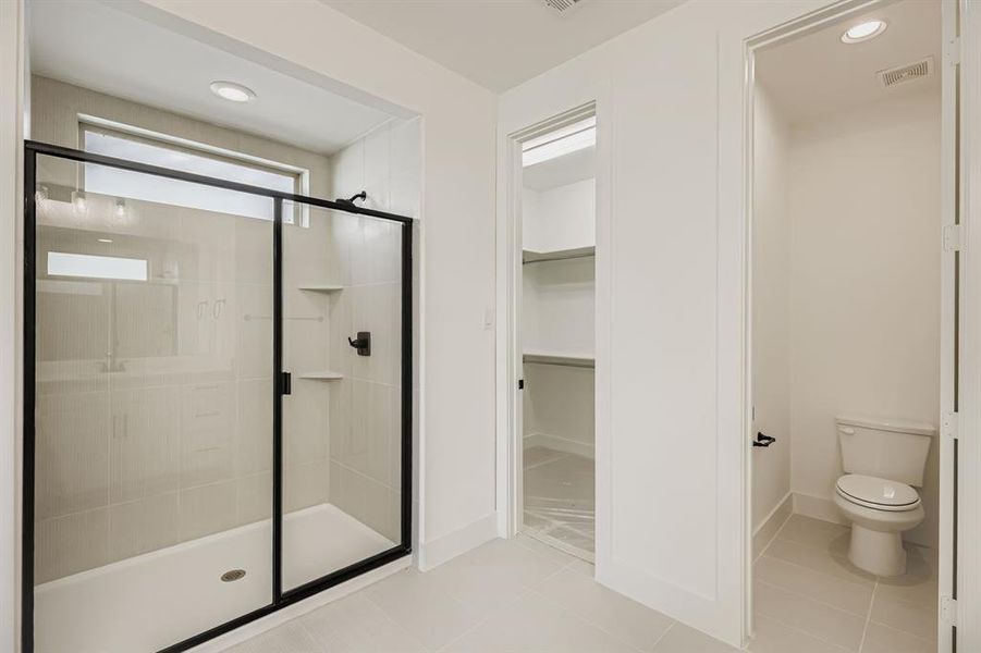 Bathroom with a shower stall, light tile patterned floors, recessed lighting, and a spacious closet Bathroom with a shower stall, light tile patterned floors, recessed lighting, and a spacious closet