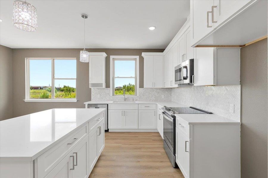 A culinary space with crisp white cabinetry and ample counter seating invites gourmet cooking. A culinary space with crisp white cabinetry and ample counter seating invites gourmet cooking.
