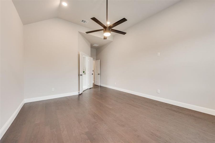 Unfurnished room with wood finished floors, high vaulted ceiling, and ceiling fan Unfurnished room with wood finished floors, high vaulted ceiling, and ceiling fan