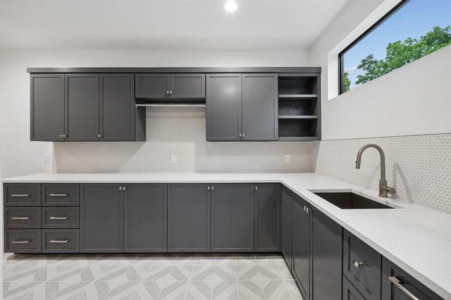 Well-appointed laundry room with extensive cabinetry, sink, and ample counter space for added functionality. Well-appointed laundry room with extensive cabinetry, sink, and ample counter space for added functionality.