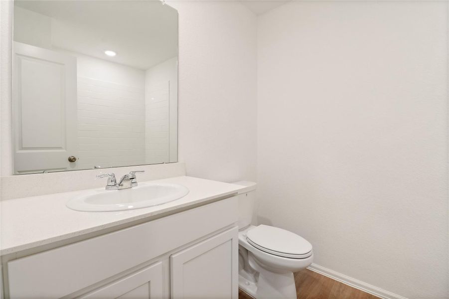 Clean and modern primary bathroom has a sleek vanity with quartz-style countertop, large mirror, and a bright tub/shower combo with classic subway tile and built-in shelving. Clean and modern primary bathroom has a sleek vanity with quartz-style countertop, large mirror, and a bright tub/shower combo with classic subway tile and built-in shelving.