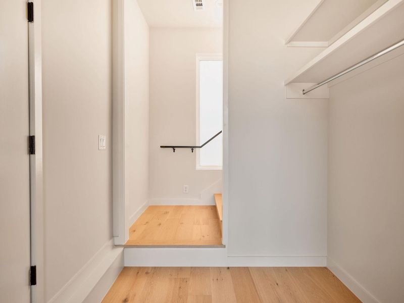 Walk in closet with light wood-type flooring