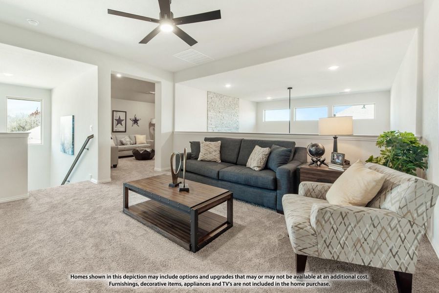 Upstairs living room with carpet, ceiling fan, gray sofa, and wood coffee table near staircase landing
