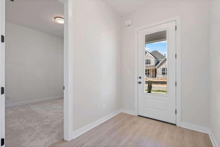 Wood-finish flooring, white paneled door with glass insert, recessed lighting, and light-toned wall paint