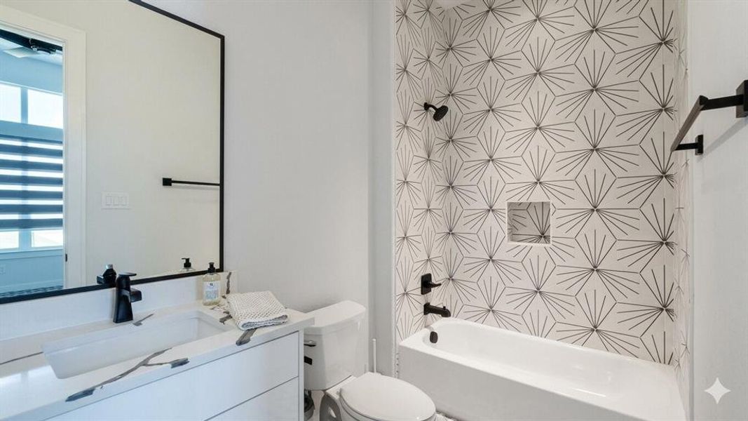 Modern bathroom featuring a striking geometric tile shower surround with a built-in niche, a soaking tub, and matte black fixtures