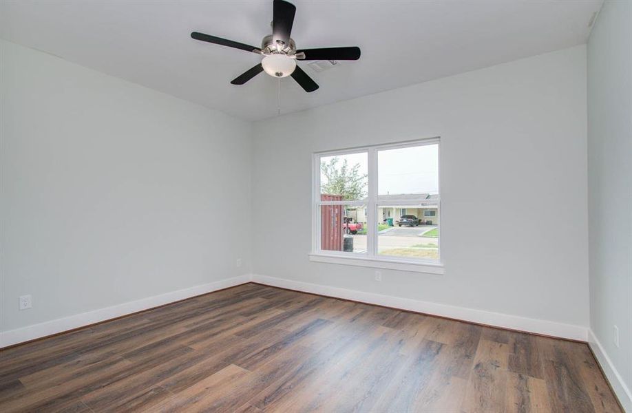 Cozy bedroom featuring energy efficient ceiling fans and natural lighting