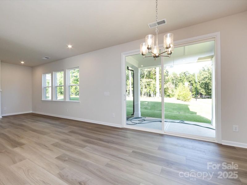 The dining room features a chandelier to center the space in warmth and light.