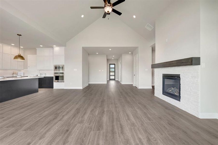 Open-concept living space with vaulted ceilings, wood-finish flooring, and recessed lighting