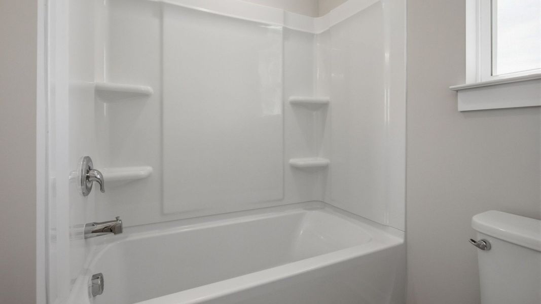 Bathroom with shower, toilet, and window Bathroom with shower, toilet, and window