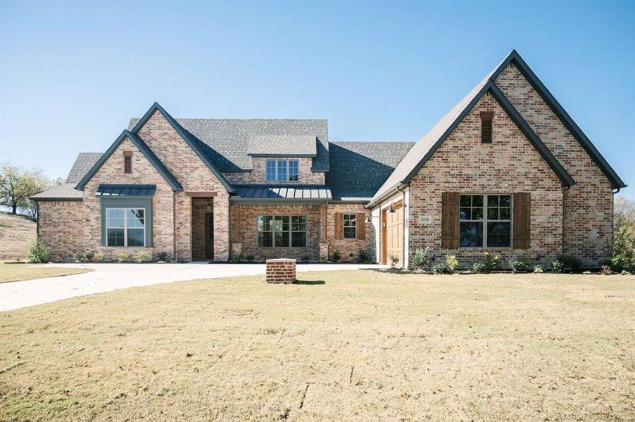 View of front of home with a garage and a front yard