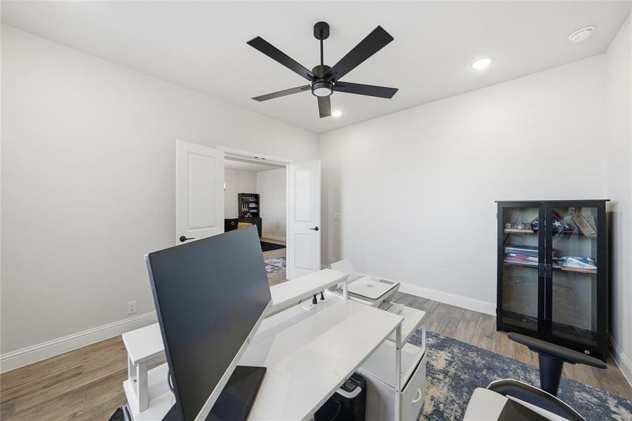 Office area featuring light wood-style floors, recessed lighting, and a ceiling fan
