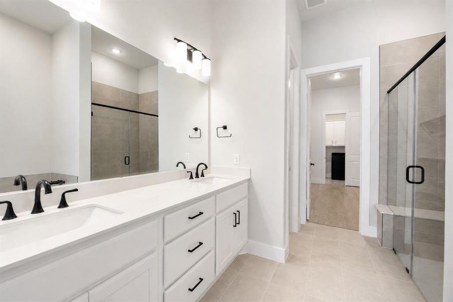 Double vanity featuring white cabinetry, integrated sinks, and matte black fixtures