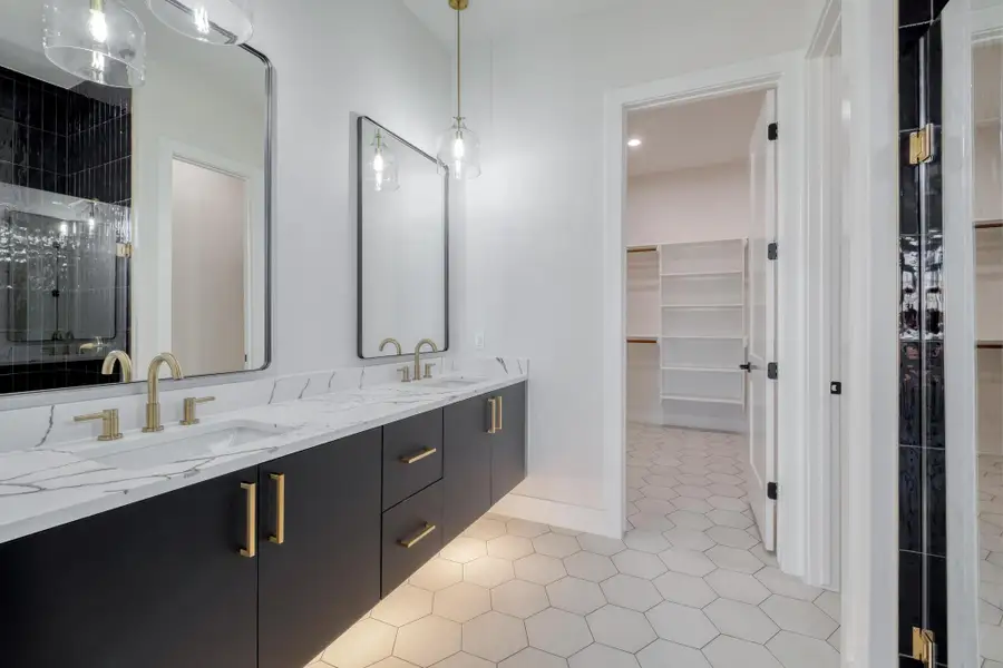 Full bath featuring tile patterned flooring, double vanity, a spacious closet, and a sink