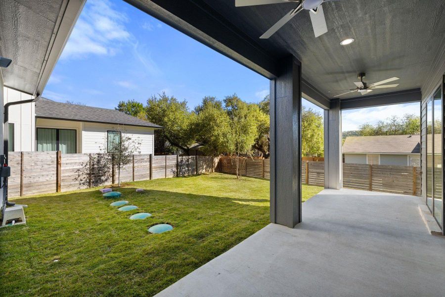 View of back yard featuring ceiling fan, a patio area, and a fenced backyard