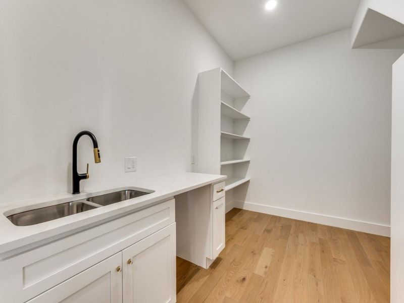 Walk in closet with sink and light hardwood / wood-style flooring