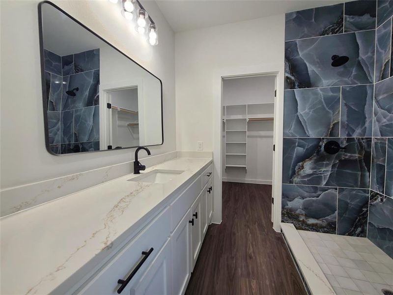 Bathroom featuring vanity, hardwood / wood-style flooring, and a shower