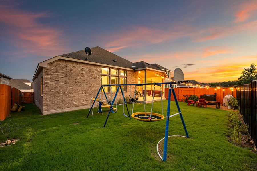 A well-maintained lawn and playset enhance the family-friendly appeal of this private backyard at sunset. A well-maintained lawn and playset enhance the family-friendly appeal of this private backyard at sunset.
