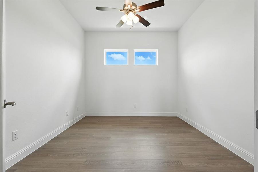 Unfurnished room with dark wood-style flooring and ceiling fan