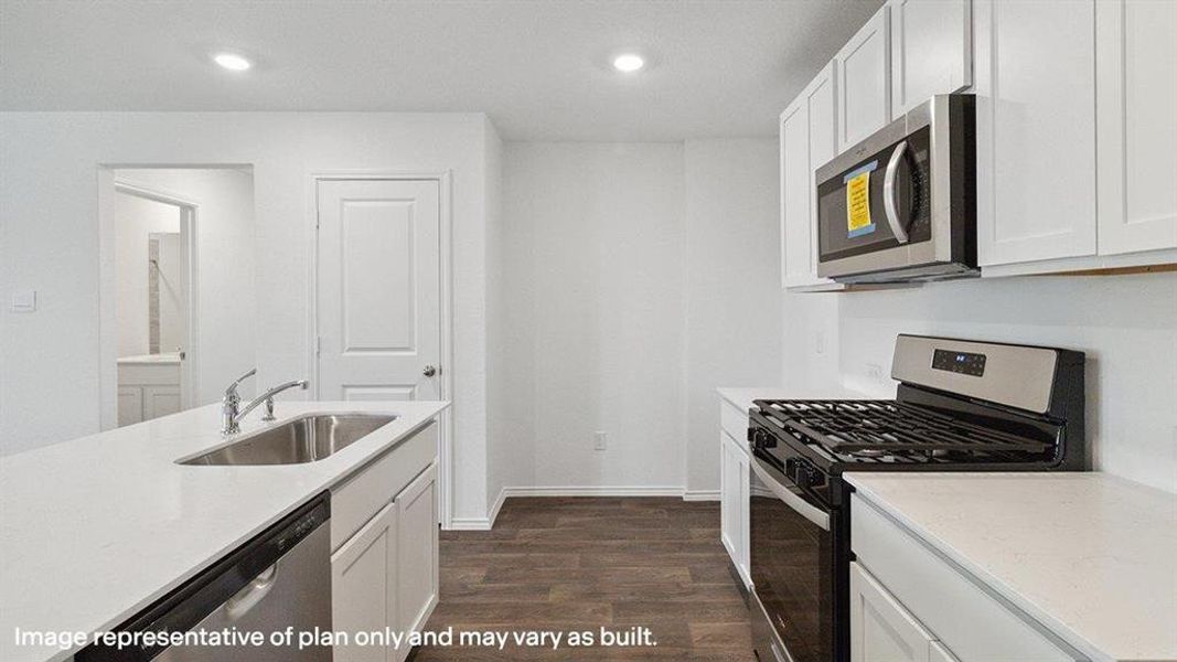 Kitchen featuring appliances with stainless steel finishes, white cabinetry, light stone countertops, dark wood-style floors, and recessed lighting