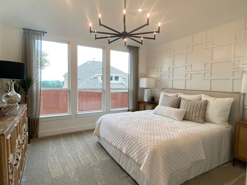 Primary bedroom with tall windows and 11' ceiling