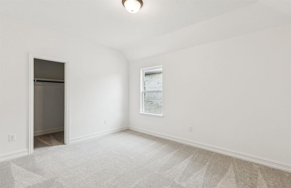 Roomy secondary bedroom with extensive closet storage  *Real home pictured