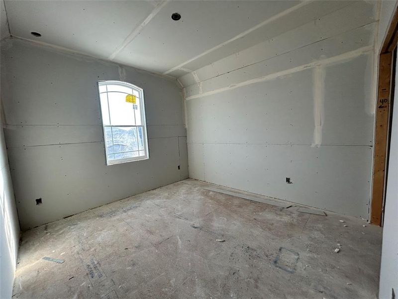 One of the three upstairs bedrooms is empty, featuring simple walls and large windows that fill the room with natural light, ready to be personalized into a cozy retreat.