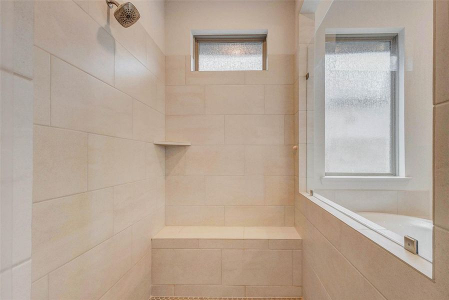 Modern bathroom shower with sleek, light-colored tiles, built-in bench, and frosted windows for natural light and privacy. Modern bathroom shower with sleek, light-colored tiles, built-in bench, and frosted windows for natural light and privacy.
