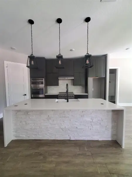 KITCHEN ISLAND WITH STANE LEDGER PANEL UNDER-SIDING, POP-UP PLUGS, FARM SINK. AND DOUBLE OVENS KITCHEN ISLAND WITH STANE LEDGER PANEL UNDER-SIDING, POP-UP PLUGS, FARM SINK. AND DOUBLE OVENS