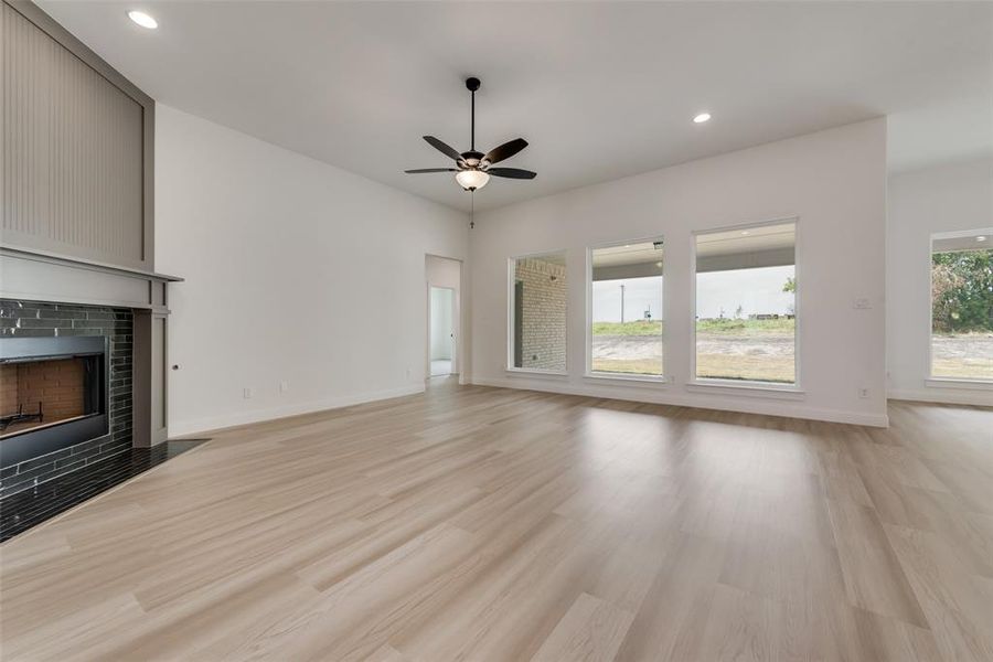 Unfurnished living room with ceiling fan and light hardwood / wood-style flooring