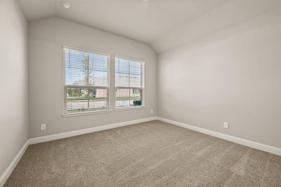 Bright secondary bedroom with large windows, neutral carpet, and plenty of natural light.