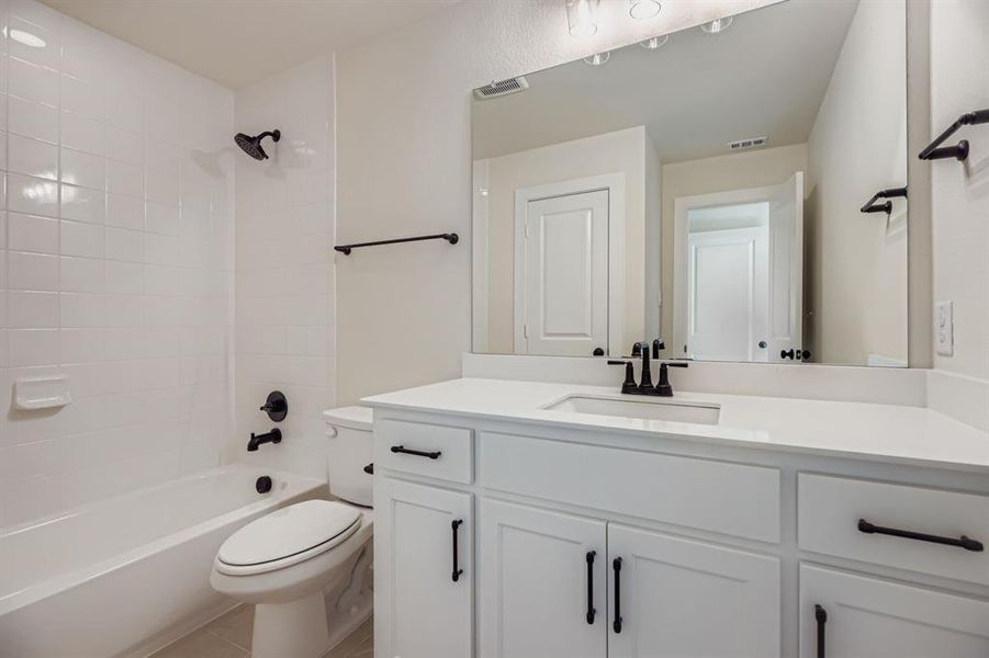Bathroom featuring vanity, bathtub / shower combination, and light tile patterned floors