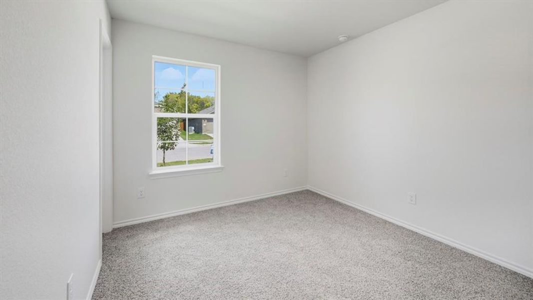 Spare room with light carpet and baseboards