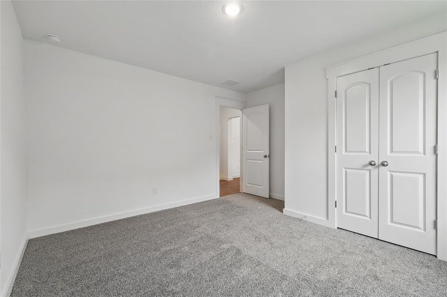 Unfurnished bedroom with carpet and a closet Unfurnished bedroom with carpet and a closet