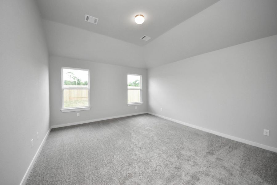 Escape to tranquility in this spacious primary room, adorned with plush carpeting and bathed in the soothing hues of warm paint colors, creating a cozy retreat for relaxation. Sample photo of completed home with similar floor plan. Actual colors and selections may vary. Escape to tranquility in this spacious primary room, adorned with plush carpeting and bathed in the soothing hues of warm paint colors, creating a cozy retreat for relaxation. Sample photo of completed home with similar floor plan. Actual colors and selections may vary.