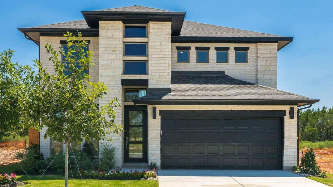 View of front of house with a shingled roof, driveway, a garage, and brick siding