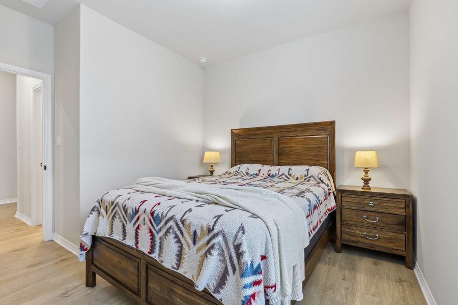 Comfortable bedroom retreat with elegant wood flooring and a bright, open feel.