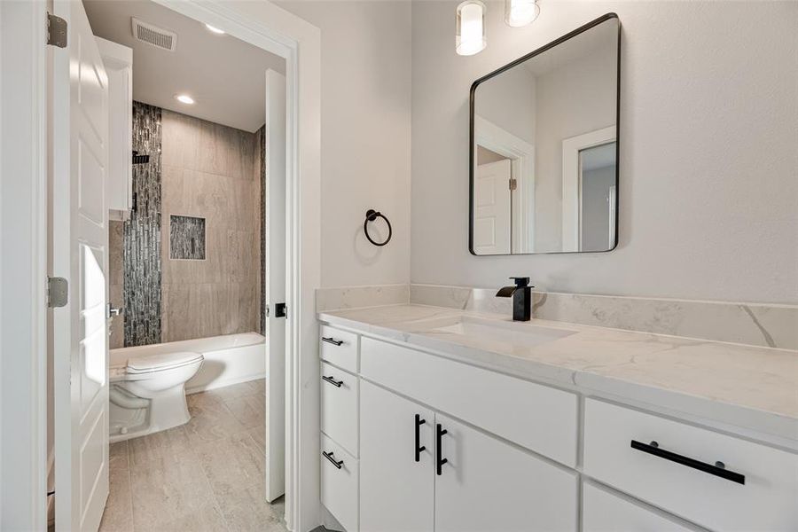 Full bathroom with vanity and shower / bath combo with shower curtain Full bathroom with vanity and shower / bath combo with shower curtain