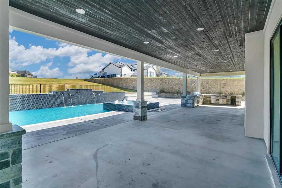 View of patio featuring pool water feature and a fenced in pool