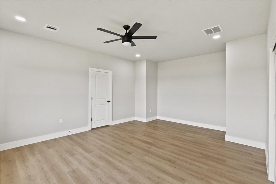 Relaxing primary suite with backyard views and a spa-inspired en suite bath featuring a fully tiled wet room, soaking tub, dual shower heads, double vanities, and a private water closet. The spacious walk-in closet includes built-in drawers for added organization.